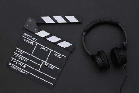 Movie clapperboard and stereo headphones on black background. top viewの写真素材