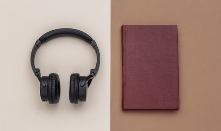 audio book. Headphones and a book on brown beige background. top view.の写真素材