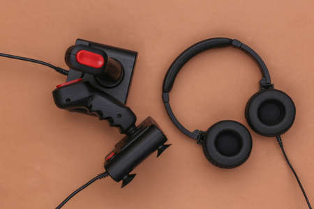 Stereo headphones with retro joysticks on brown background. top view. flat layの写真素材