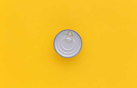 Metal can of canned food on blue pink background. top view