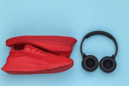 Sports shoes with stereo headphones on a blue background. top viewの写真素材