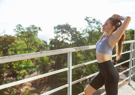Young slim fit woman exercising outdoors