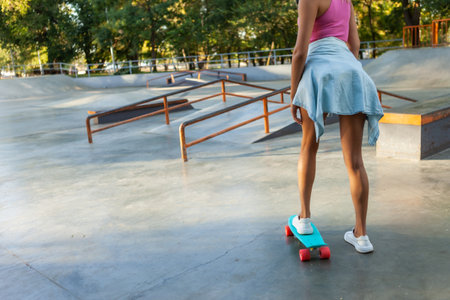 Crop photo of female skater with cruiser board at skateparkの写真素材