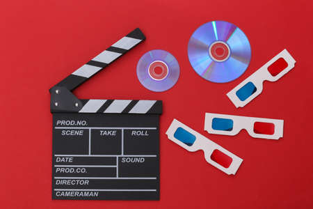 Film clapper board and cd's, 3d glasses on red background. Cinema industry, entertainment. top view
