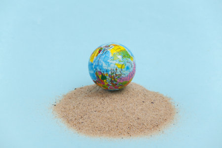 Summer beach travel concept. Globe on an island with sandの写真素材