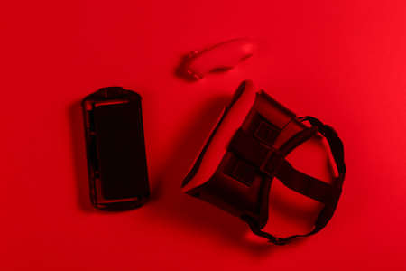 Virtual reality headset with joystick, smartphone in red vibrant neon light.の写真素材
