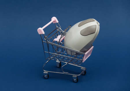 Mini shopping trolley with retro pc mouse on classic blue backgroundの写真素材