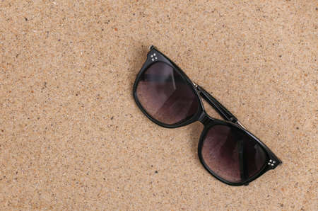Summer beach travel concept. Sunglasses on sandの写真素材