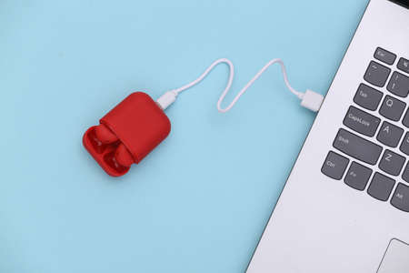 Wiireless headphones in the case charged by the laptop. top view