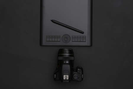 Graphic tablet with pen, camera on black background. top viewの写真素材