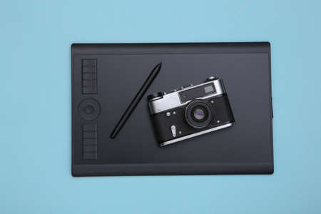 Graphic tablet with pen and camera on blue background. top viewの写真素材