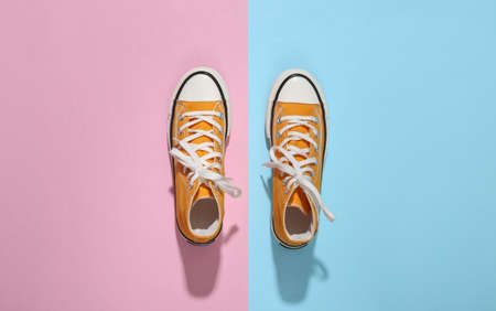 Yellow high-top sneakers (gumshoes) on pink blue bright background. top view. minimalismの写真素材