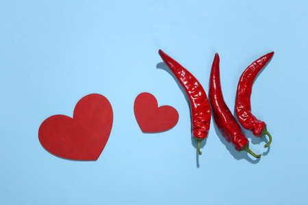 Chilli pepper and heart on blue background. love concept. top viewの写真素材