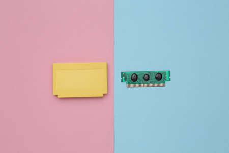 Retro video game cartridge on pink blue background. top viewの写真素材