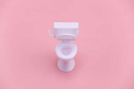 Mini white toilet on pink background. minimalism. top viewの写真素材