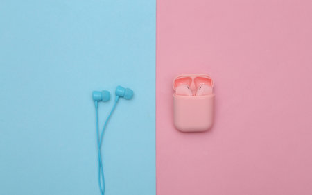 Wireless and wired headphones on a pink-blue pastel background. top viewの写真素材