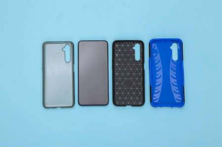 Smartphones with protective cases on a blue background. top viewの写真素材