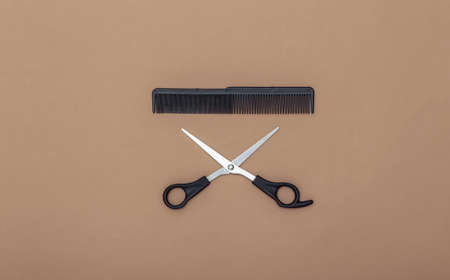 Comb and scissors on a brown background. barber tool. top viewの写真素材