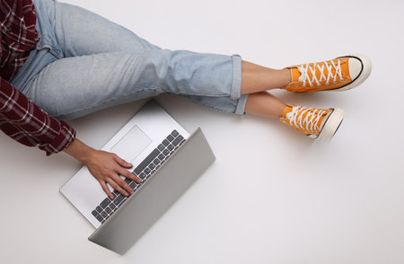 Remote (remote), online work or education. Woman with laptop sits on white background. freelance concept. top view. flat layの写真素材
