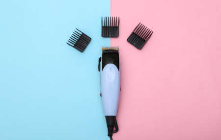 Hair clipper with attachments on pink blue pastel background. top viewの写真素材