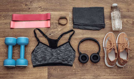 Flat lay composition of Sports equipment, clothes on a wooden floor. Fitness, sport and healthy...