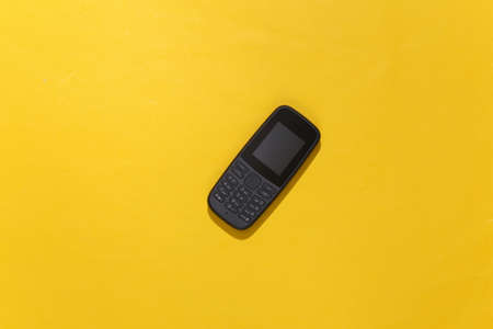 Push-button telephone on yellow background. top viewの写真素材