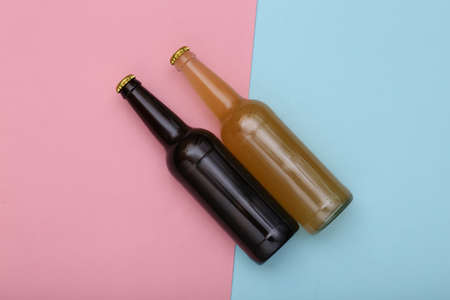 Bottle of light and dark beer on pink blue background. top viewの写真素材