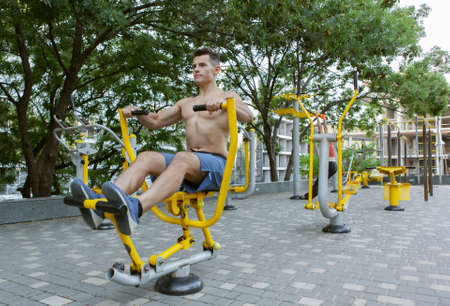 Muscular man is exercising on outdoor machines. healthy lifestyle conceptの写真素材