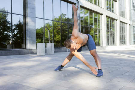 Young athletic man doing warm-up before outdoor workout. healthy lifestyle. fitness concept