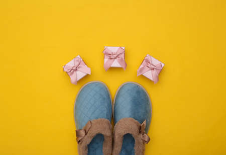 Women's sleeping slippers and gift box on yellow background. christmas concept. top viewの写真素材