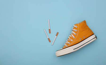 Conceptual shot of cigarettes and gum shoe on blue background. top viewの写真素材