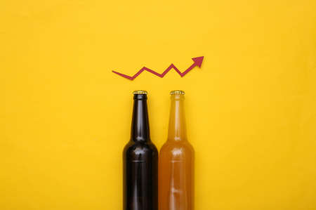 Beer bottles and an upward growth arrow on a yellow background.の写真素材