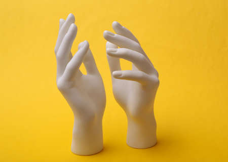 White Hands mannequin stand on yellow background. minimalism. creative art