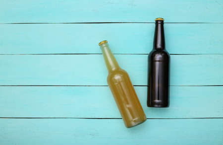 Two bottles of dark and light beer on blue wooden background. top view.の写真素材