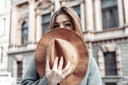 The woman covered her face with a felt hat. Fashion shot of a young attractive womanの写真素材