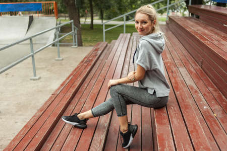 Fitness woman sitting on tribune outdoorsの写真素材