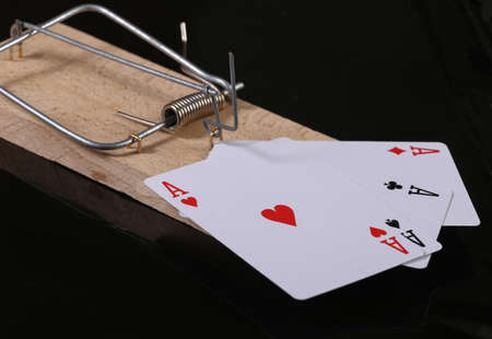 Mousetrap with four aces isolated on black background. Gambling addiction