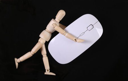 Wooden puppet mannequin holding pc mouse isolated on black background