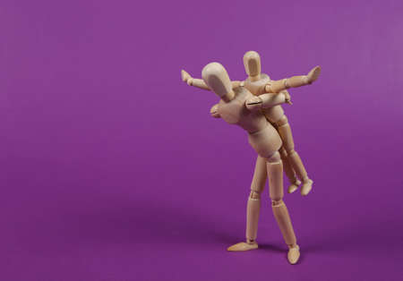 Two puppets impersonating a guardian and a child fooling around against purple background. Spending time togetherの写真素材