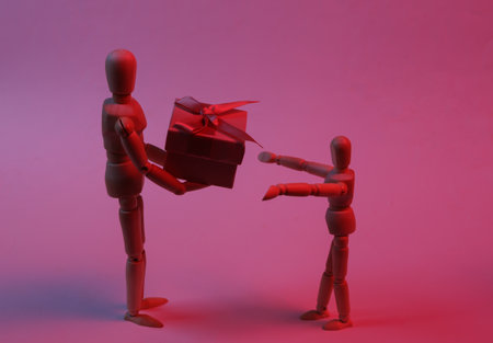 Wooden puppet presents a gift box in neon lightの写真素材
