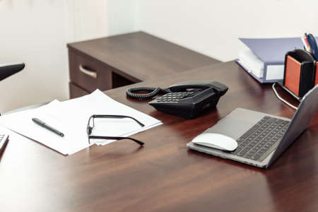 Workspaces of office workers. Desk with laptop, phone and accessoriesの写真素材