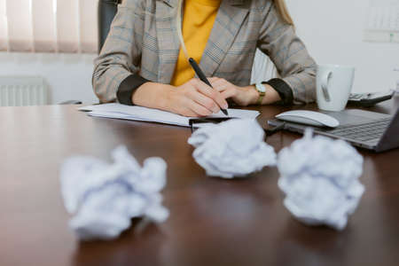 Woman boss with crumpled paper balls in her officeの写真素材