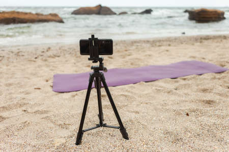 Smartphone on a tripod at the beach. Fitness blog concept.の写真素材
