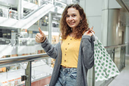 Smiling woman with shopping bags at the shopping mallの写真素材