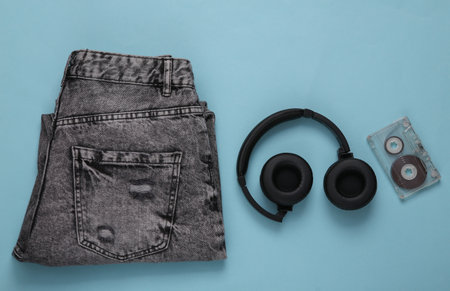 Retro audio cassette, gray jeans, headphones on blue backgroundの写真素材