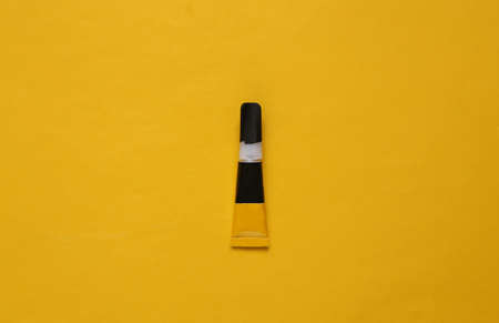 Tube of glue on a yellow background. top viewの写真素材