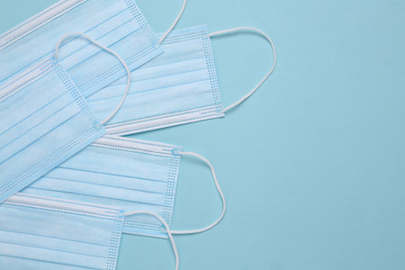 Medical facial masks on a blue background with copy space. top view