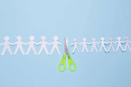 Paper cut chain of people with scissors on blue background