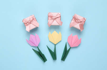 Handmade origami tulips and gift boxes on blue background. March 8, women's day concept. top view. minimalismの写真素材
