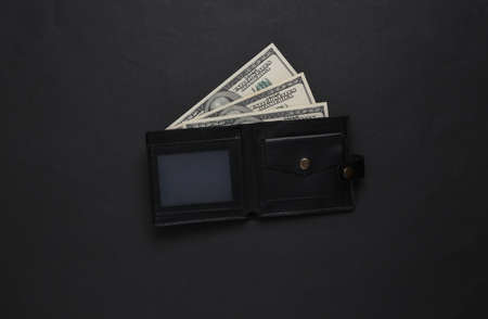 Leather wallet with one hundred dollar bills on black background. top viewの写真素材